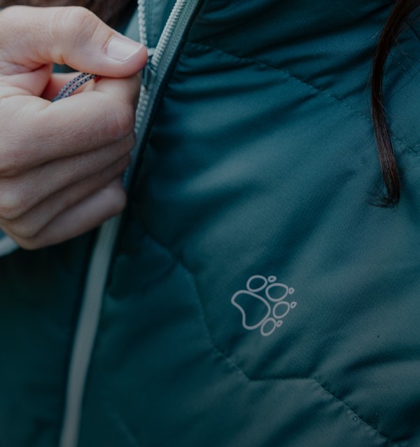 Primer plano de una mano en la cremallera de una chaqueta.