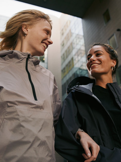 Dos mujeres pasean sonrientes por la ciudad