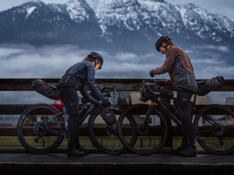 Dos ciclistas en un paisaje montañoso con niebla