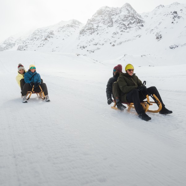 Tres personas sentadas en un trineo en la nieve