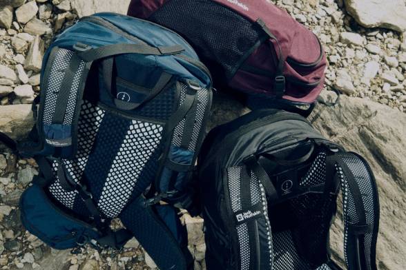Toma de tres mochilas de senderismo sobre un suelo rocoso