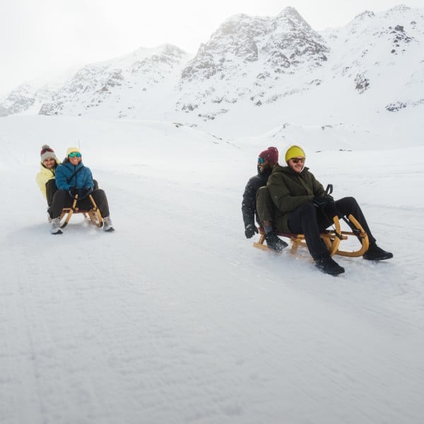 Tres personas sentadas en un trineo en la nieve