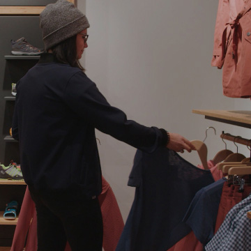 Dependienta en una tienda con zapatos en el fondo