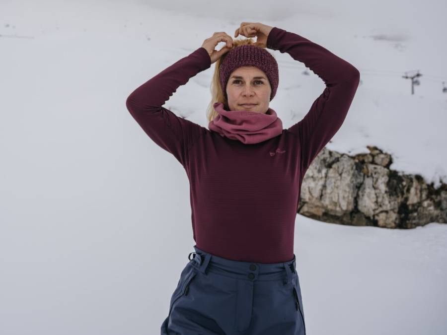 Mujer con ropa interior térmica en un paisaje montañoso nevado