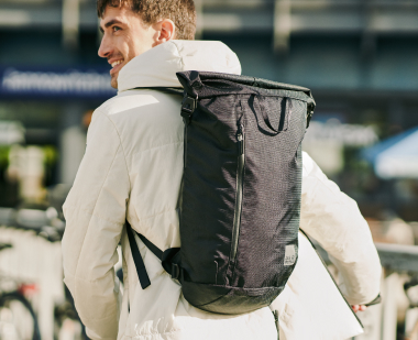 Hombre con mochila con cierre enrollable a la espalda