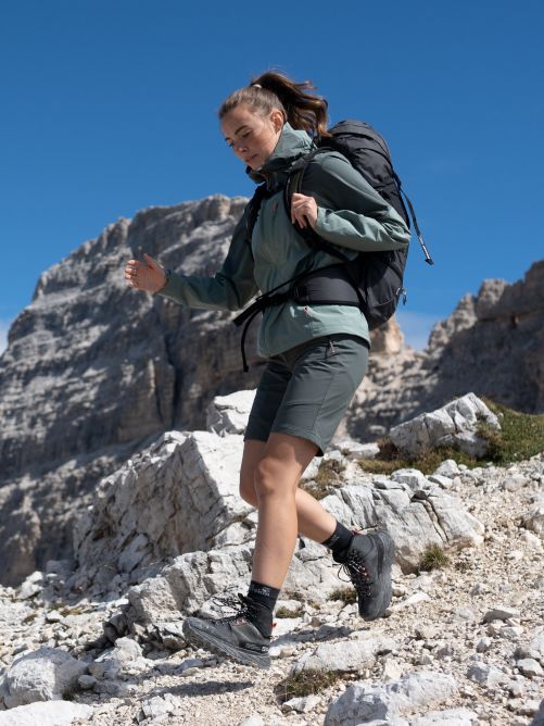 Una senderista con una mochila grande camina montaña abajo