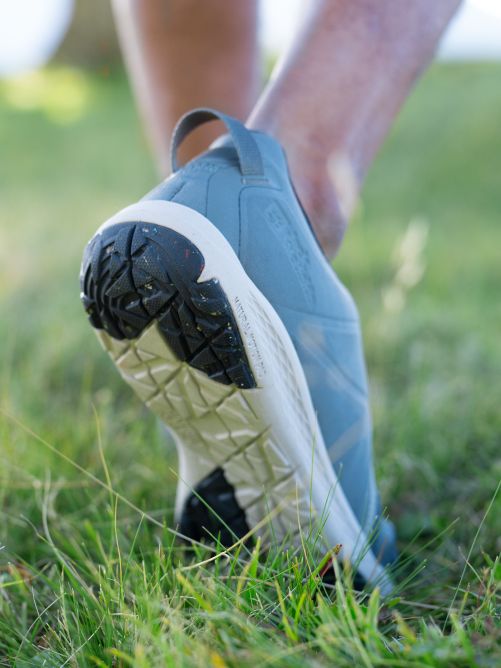 Detalle de una suela de zapato por atrás en la hierba