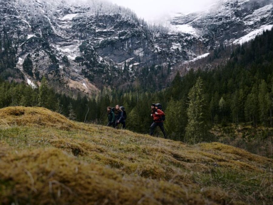 Tres excursionistas con equipo de senderismo en las montañas