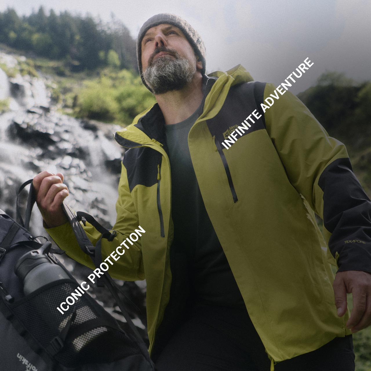 Un señor con una chaqueta amarilla, un gorro beis y una mochila rodeado de naturaleza mira hacia arriba. El texto dice: «Iconic Protection» e «Infinite Adventure»