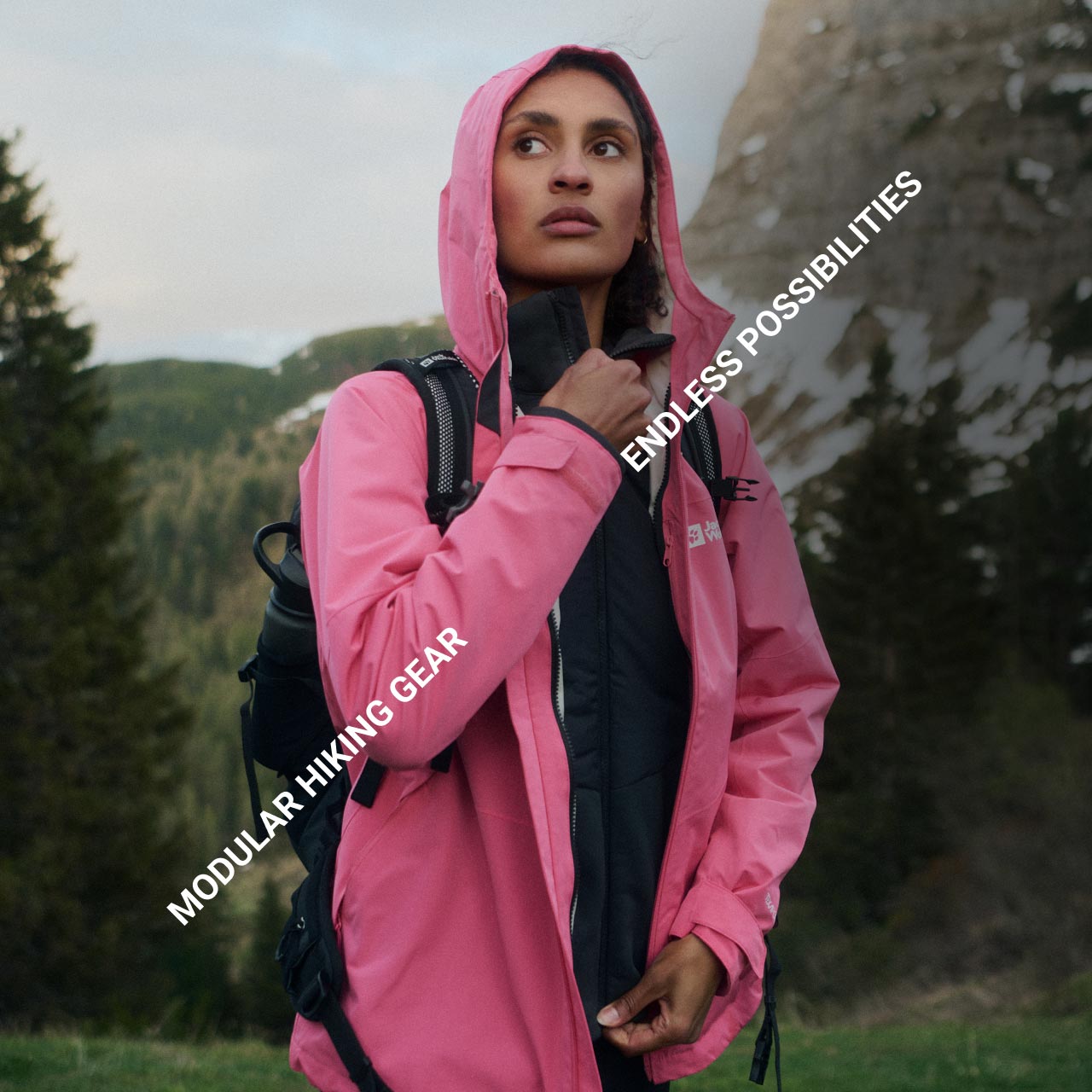 Una persona con una mirada pensativa vestida con una chaqueta rosa en un paisaje forestal y montañoso. El texto dice: «Modular Hiking Gear» y «Endless Possibilities»
