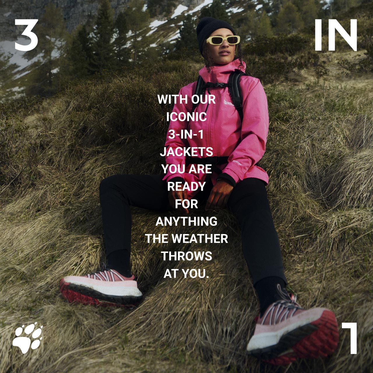 Una persona con chaqueta rosa y gorra sentada en una ladera cubierta de hierba, con gafas de sol y botas de montaña. El texto dice: «With our iconic 3-in-1 jackets, you are ready for anything the weather throws at you.»